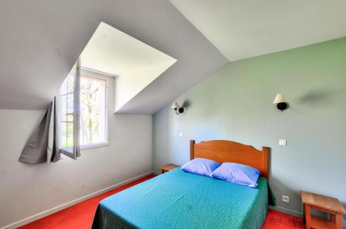 une chambre avec un lit bleu et une fenêtre dans l'établissement La résidence du Lac - maeva Home - Appartement 2 pièces 5 personnes - Sélection MAE-5051, à Monflanquin