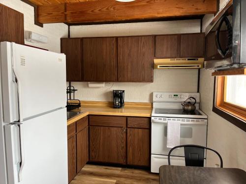 a kitchen with a white stove and a refrigerator at Snow Otter Haus in Bessemer