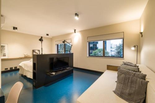 - un salon avec un sol bleu, un lit et une télévision dans l'établissement BHomy Itaim Perto Rua Amauri e Faria Lima CL142, à São Paulo