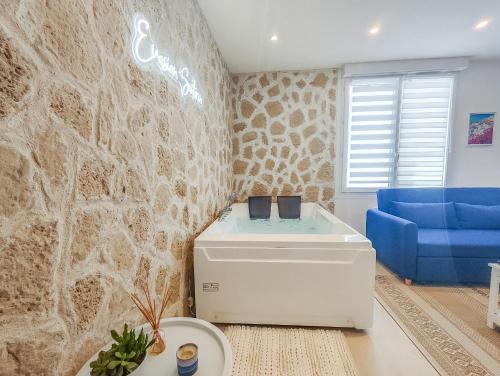 sala de estar con sofá azul y pared en Évasion Santorin - Jacuzzi & Relax, en Le Havre