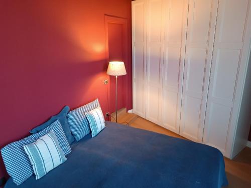 sypialnia z niebieskim łóżkiem i czerwoną ścianą w obiekcie Vicodeifiori w mieście Acireale