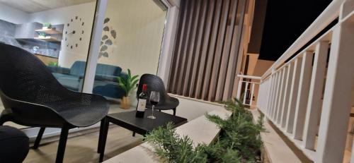 a living room with two chairs and a wine bottle on a table at B8 Seaside Luxury Rooms with private bathroom - dining area shared in St Paul's Bay