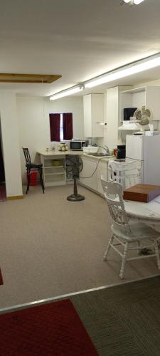 Cette chambre comprend une cuisine avec deux chaises et une table. dans l'établissement Sweet suite, à Houghton