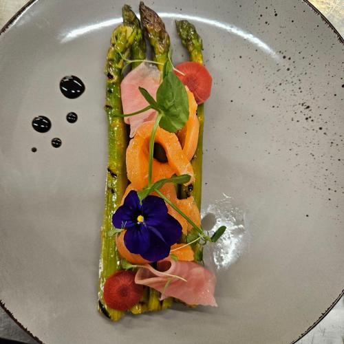 a plate with a sandwich with vegetables and a flower on it at Hôtel Aster Restaurant Aux Arcades in Briey