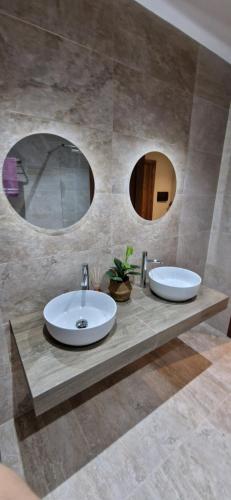 two sinks in a bathroom with two mirrors at B8 Luxury Suites - brand NEW - just 2 mins from the beach in St. Paul's Bay