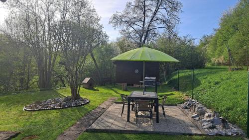 a table with a green umbrella in a garden at Chata v Moravském krasu in Sloup