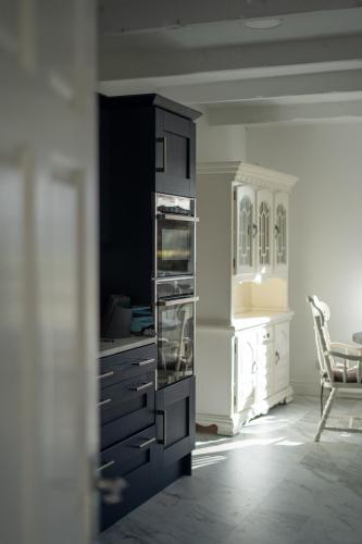 a kitchen with black cabinets and a table and a chair at Glen Lodge in Ballymoney
