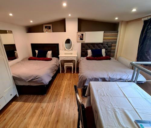 um quarto com 2 camas, uma mesa e um espelho em The Lodge em Dublin