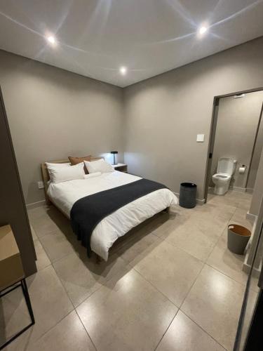 a bedroom with a large bed and a toilet at On Fredman Drive in Johannesburg