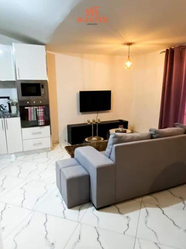 - un salon avec un canapé et une télévision dans l'établissement App Cidadela, à Praia