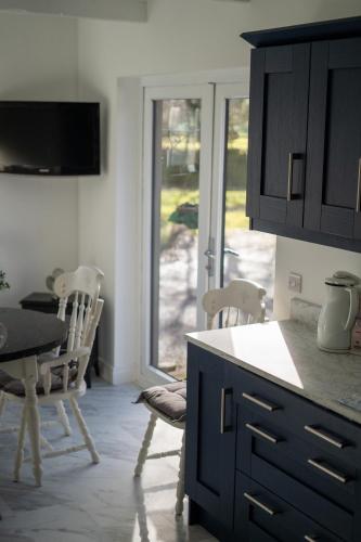 a kitchen with a counter and a table and chairs at Glen Lodge in Ballymoney