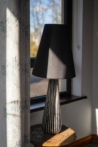 a lamp sitting on a table next to a window at Glen Lodge in Ballymoney