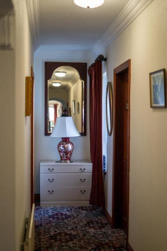 a room with a dresser with a lamp and a mirror at Glen Lodge in Ballymoney