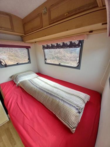 a bed in the back of a caravan at The Lakeside Cabin in Longmorn