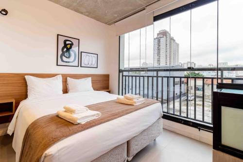 ein Schlafzimmer mit einem großen Bett und einem großen Fenster in der Unterkunft BHomy Bom Retiro - Pertinho do Sambódromo VIT404 in São Paulo