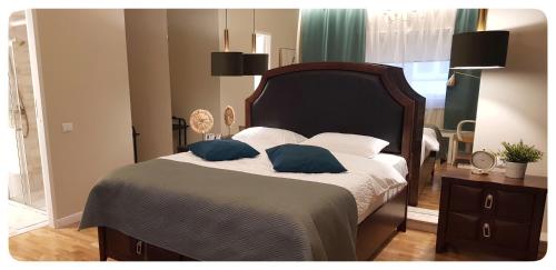 Elania Residence في تارغو جيو: غرفة نوم مع سرير مع وسادتين زرقاوين