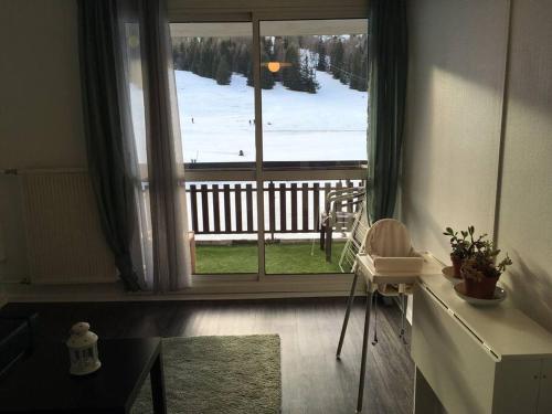 a room with a large window with a view of a snow covered yard at Beau studio plein sud dans résidence tout confort in Le Dévoluy
