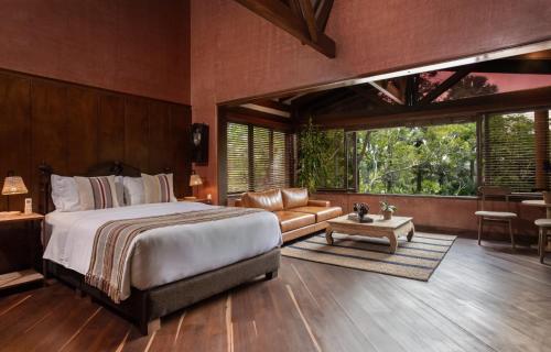 a bedroom with a bed and a couch and a table at Sazagua Hotel Boutique in Pereira