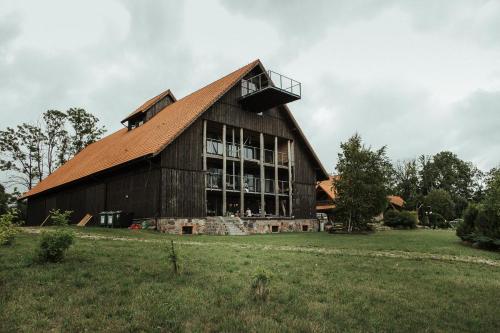 um grande celeiro de madeira com telhado de metal em Poganty - Obora em Giżycko
