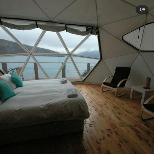 a bedroom with a bed and a large window at Terra Luna Lodge in Puerto Guadal