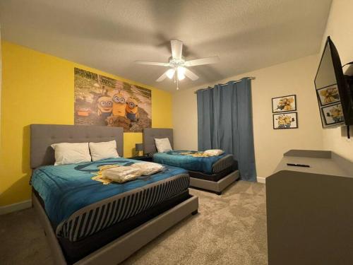 a bedroom with two beds and a ceiling fan at 4BR Townhouse Private Pool BBQ Near Disney in Kissimmee