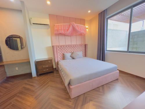a bedroom with a bed with a pink headboard and a window at Private 5Brs Pool Villa Luxurious Furniture in Danang