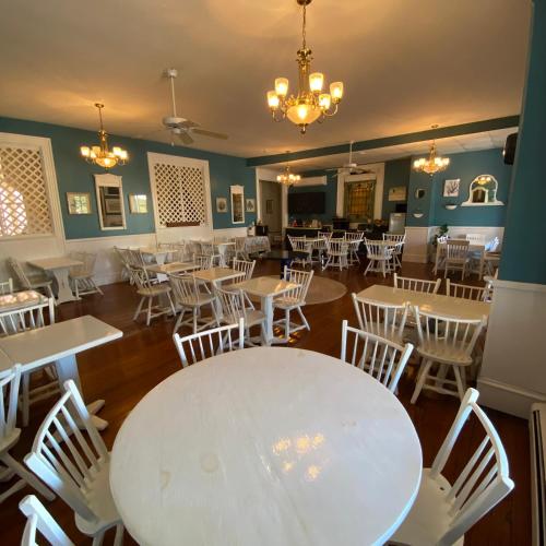 a dining room with a white table and chairs at The Ocean House in Spring Lake