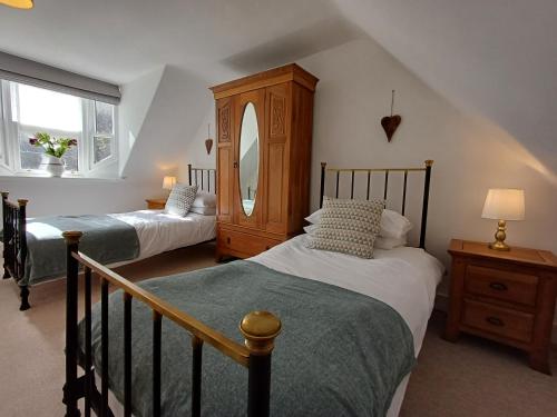 卡倫的住宿－Creel Cottage，一间卧室配有两张床、一个梳妆台和镜子