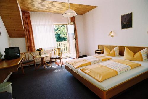 pokój hotelowy z dużym łóżkiem i stołem w obiekcie Hotel Zum Schneekopf "Garni" w mieście Gehlberg