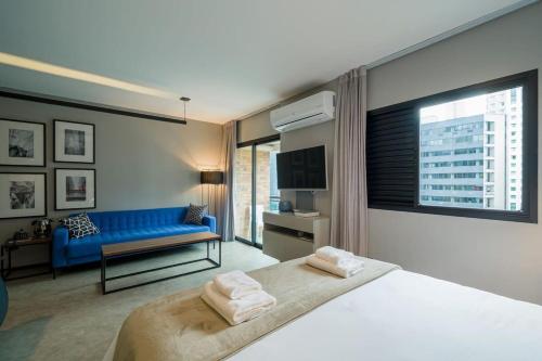 1 dormitorio con 1 cama grande y 1 sofá azul en BHomy Brooklin Ao lado do WTC e Berrini ET802, en São Paulo