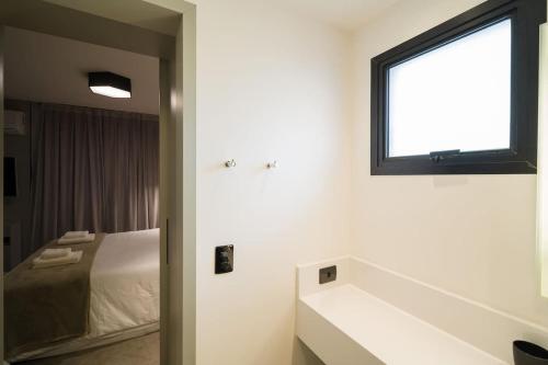a bathroom with a bed and a window and a sink at BHomy Brooklin Ao lado do WTC e Berrini ET802 in São Paulo
