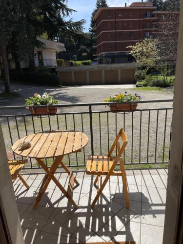 einen Holztisch und einen Stuhl auf dem Balkon in der Unterkunft Appartamento Gaia - a due passi dal centro in Laveno-Mombello