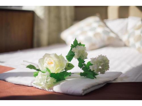un ramo de flores blancas sentado en una cama en Tabata Oji Hotel - Vacation STAY 89860v, en Tokio