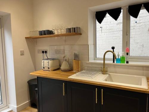a kitchen counter with a sink and a window at NEW! 3 Bed House with Pool Table, Parking, Netflix in Nottingham