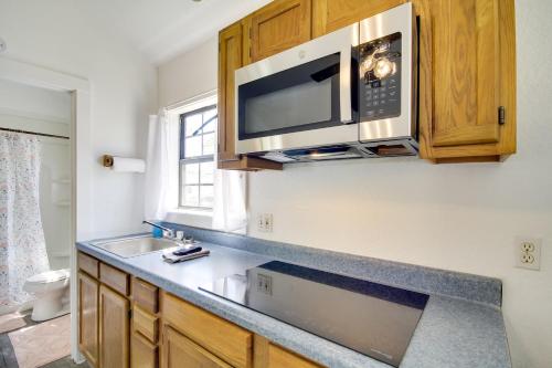 a kitchen with a sink and a microwave at Charming Biloxi Studio with Community Pool and Lake! in Biloxi