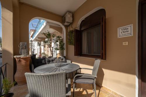 un patio con mesa, sillas y sofá en villa Chris en Pylos