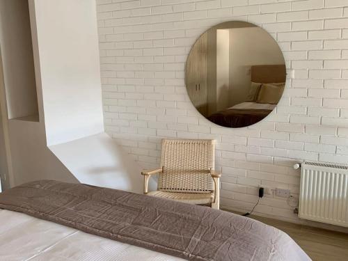 a bedroom with a mirror and a chair and a bed at HOM I En Cerro Baron Cómodo Loft Jardín, Estacionamiento 1709 in Valparaíso
