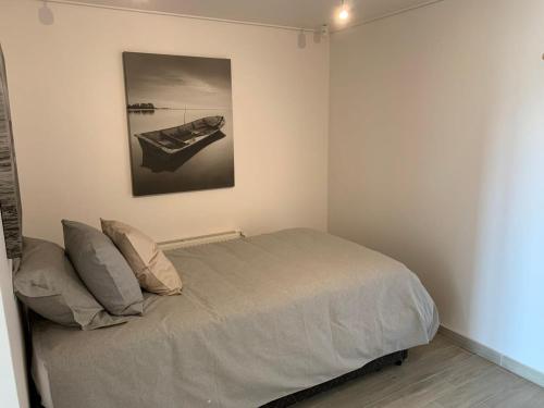 a bedroom with a bed with a painting on the wall at HOM I En Cerro Baron Cómodo Loft Jardín, Estacionamiento 1709 in Valparaíso