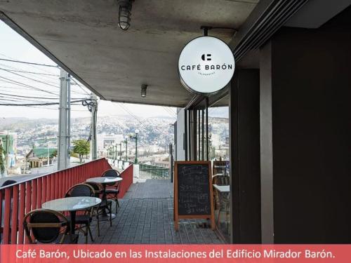 a restaurant with tables and chairs on a balcony at HOM I En Cerro Baron Cómodo Loft Jardín, Estacionamiento 1709 in Valparaíso