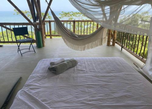 a bed on a porch with a hammock and a chair at La Cometa - Palomino in Palomino