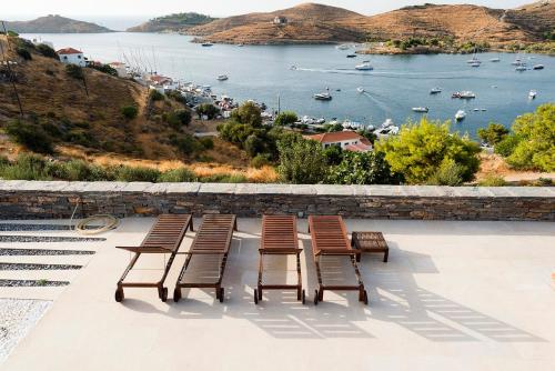 a group of chairs sitting on a patio overlooking a harbor at House garden in Ioulis