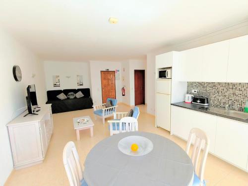 a kitchen and a living room with a table and chairs at DUNAS DO ALVOR by LTS Holidays - #127 in Alvor
