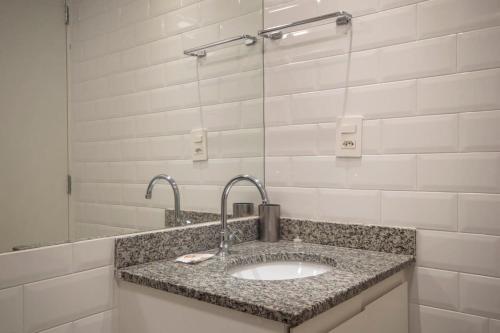 W łazience znajduje się umywalka i lustro. w obiekcie BHomy República Completo e Renovado VB1812 w São Paulo