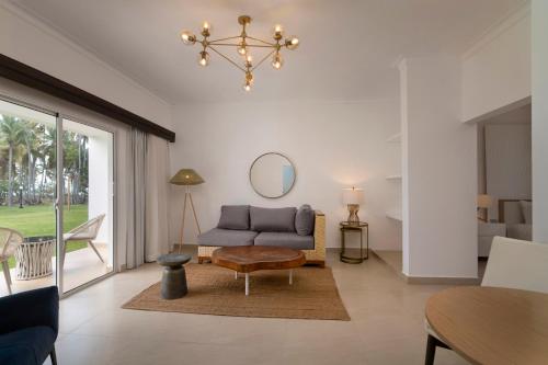 a living room with a couch and a mirror at Wyndham Alltra Samana All Inclusive Resort in Las Galeras