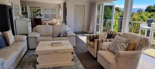 a living room with couches and a coffee table at Coastal Chic in Pohara in Pohara