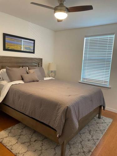 a bedroom with a large bed with a ceiling fan at Updated,spacious, maritime 3BR downtown cottage in St. Augustine
