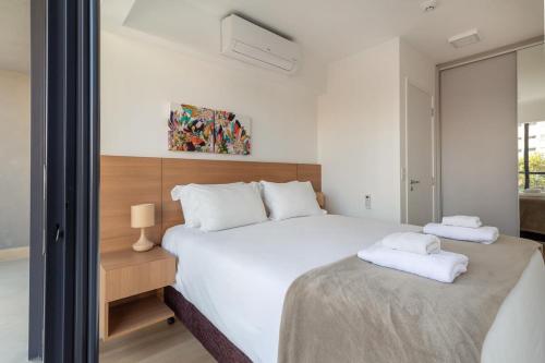 a bedroom with a large bed with two towels on it at BHomy Perdizes Novo e perfeito para 4 DH302 in São Paulo