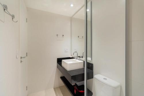 a white bathroom with a sink and a mirror at BHomy Perdizes Novo e perfeito para 4 DH302 in Sao Paulo