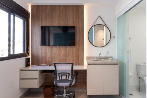 een badkamer met een bureau, een wastafel en een spiegel bij BHomy V Madalena - Studio novo e completo UP305 in Sao Paulo