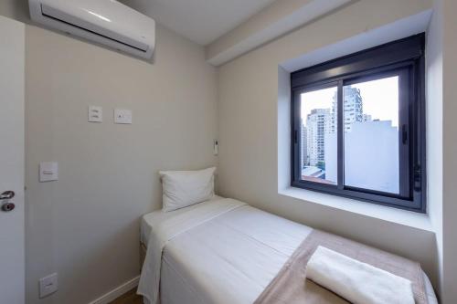 ein kleines Schlafzimmer mit einem Bett und einem Fenster in der Unterkunft BHomy Perdizes - Garagem e piscina c vista VA802 in São Paulo